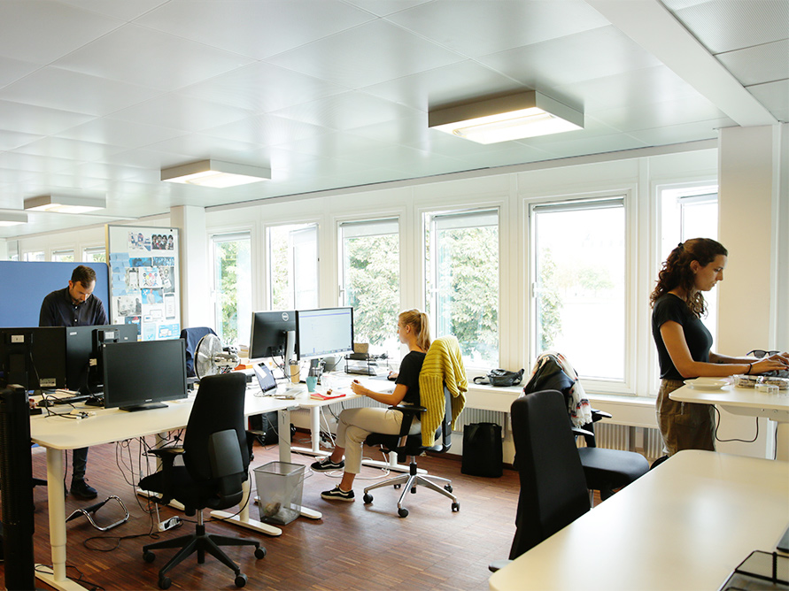 Et billede på Debitoor kontroret med medarbejdere der arbejder ved deres skrivebord